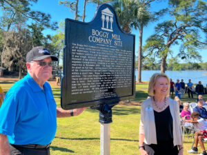 Man and woman stand by a plaque