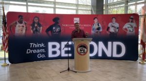 a man standing in front of a banner for northwest Florida state college