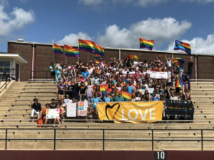a group of people posing for a photo in bleachers of a stadium