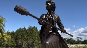 a bronze statue of a woman with cannon implements.
