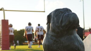 Niceville Defensive linemen, Nathaniel Kridle and Peyton Holloway warm-up for their game against the Crestview Bulldogs in the background of this photo which features the Crestview bulldog and statue form.