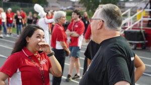 Okaloosa County school board member, Tim Bryant, and an administrator of the big red machine marching band of Crestview share a laugh before the game between the Niceville Eagles and the Crestview Bulldogs