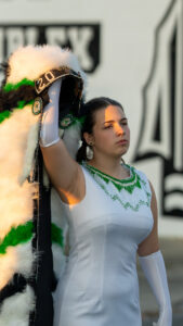 The Choctawhatchee high school drum major holds her traditional headdress above her head as she and the Choctawhatchee style marchers prepare to march onto the field for the pregame ceremonies at Joe Etheridge field in Fort Walton Beach.