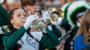 A choctawhatchee high school trumpeter marches forward with her comrades in the style marchers band to kick off the game between Niceville high school and Choctawhatchee high school.