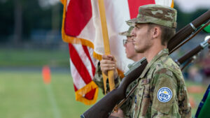 A Choctawhatchee high school junior ROTC cadet stands at attention with the colors before marching onto the field for the pledge of allegiance and national anthem that proceeded every home game at Joe Etheridge stadium.