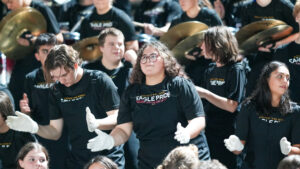 Isabel Soto claps along with her bandmates in the Eagle Pride Band. The band would boost the Eagles to a 42-25. Victory over the Choctawhatchee High School Indians.