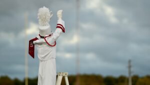 Crestview high school drum major leads the band in their pregame performance to welcome both teams to the field and play the national anthem.