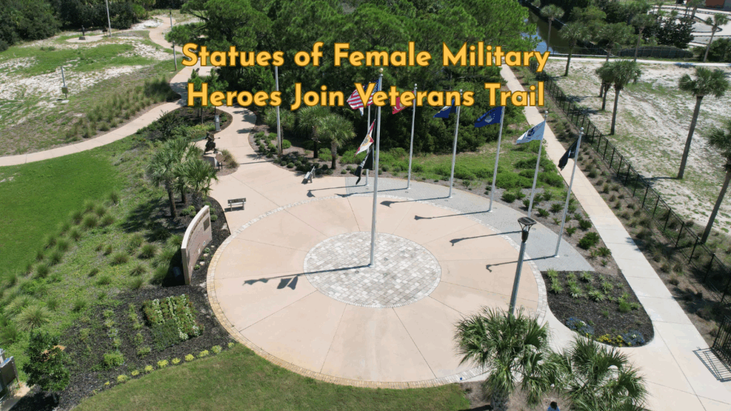 Aerial view of Veterans Park on Okaloosa Island, featuring flagpoles, winding pathways, and surrounding greenery near the shoreline.