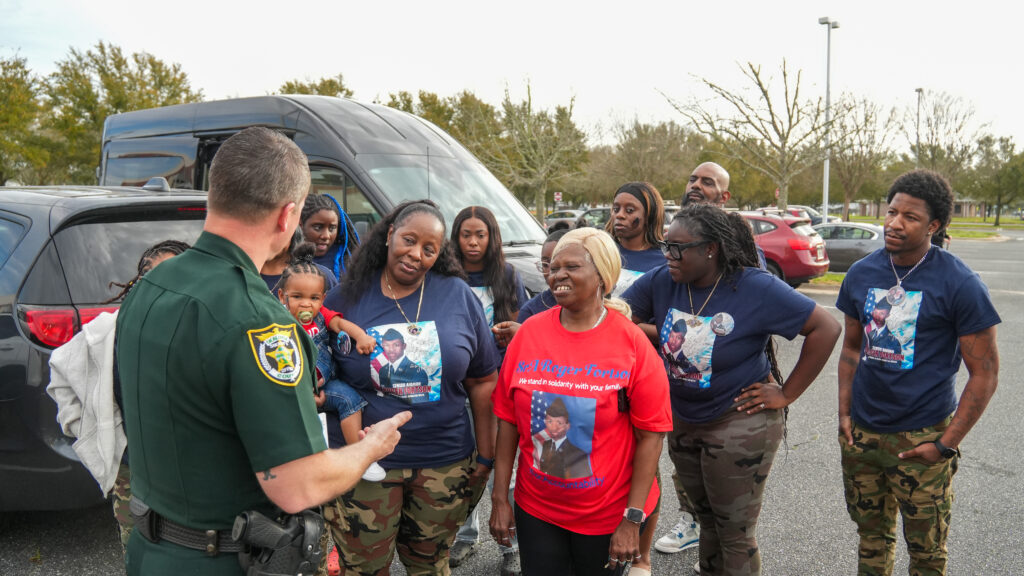 a law enforcement officer speaking with a group of people.