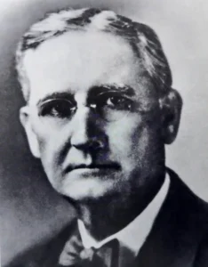 a man with glasses and a bowtie.