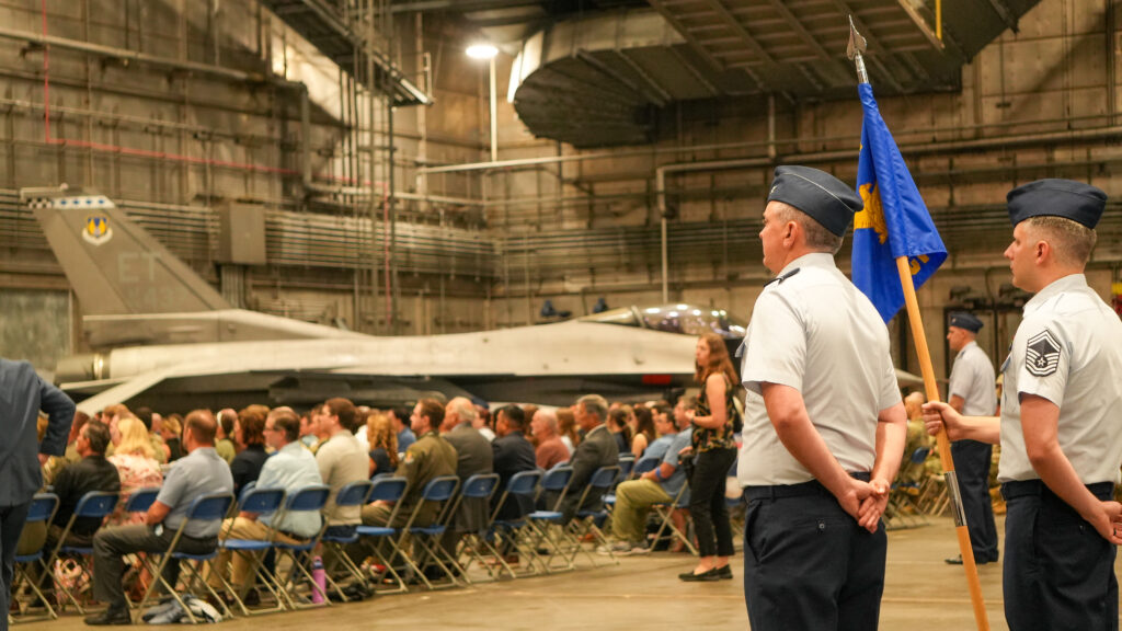 An F-16 viper looms in the background as members of the cyber space test group prepared to welcome their new commander to Eglin Air Force Base in the 96 testing Colonel Chris Keithley