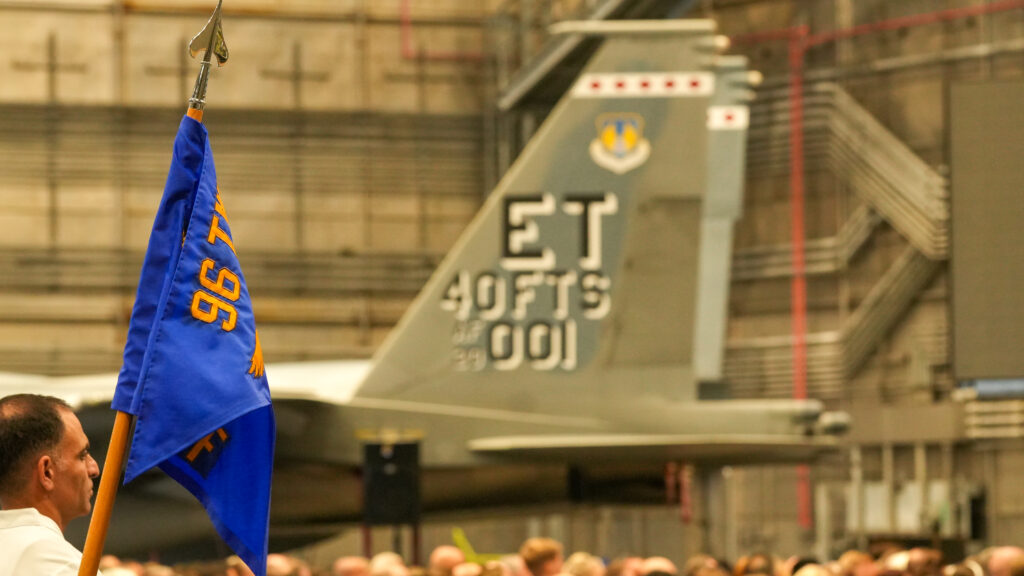 And 96 test wing guide on stands in the foreground in front of the tail flash of an echo test wing F 15 EX.