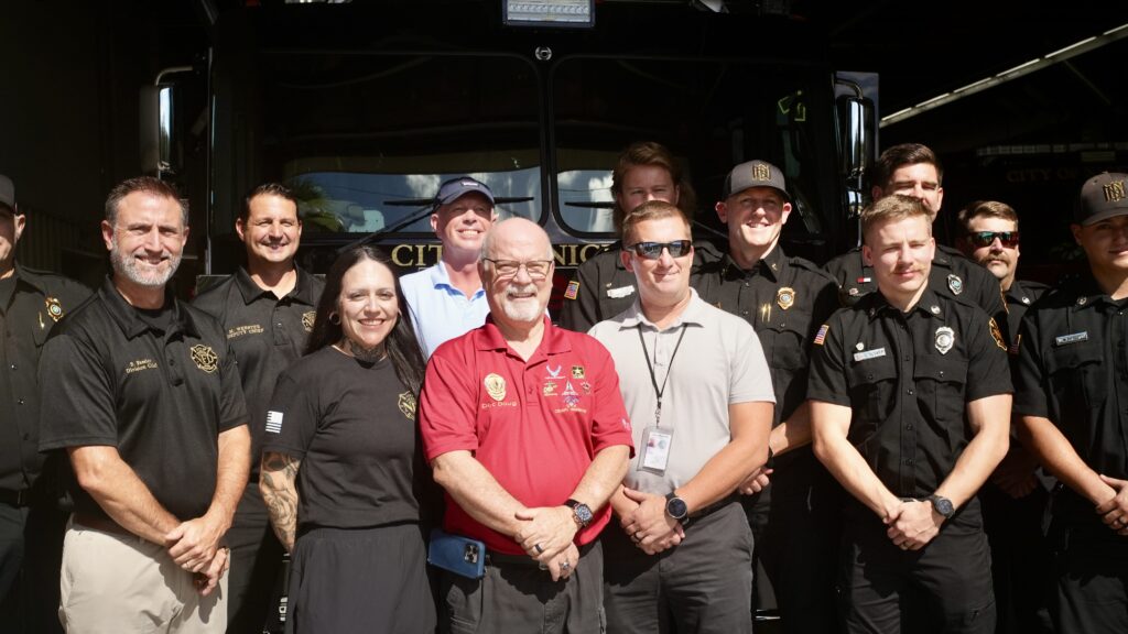 A bunch of people standing in front of a fire truck