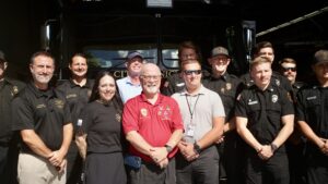 A bunch of people standing in front of a fire truck